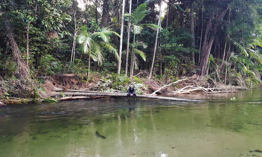 Tour guide Will sits at the bank of the Mossman River in far north Queensland. Photo: Melissa Iaria / AAP