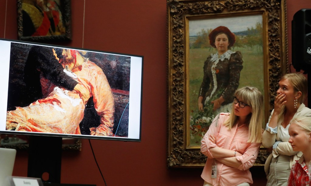 Visitors looks at a monitor showing the damaged Ilya Repin painting at the Tretyakov Gallery. Photo:  EPA
