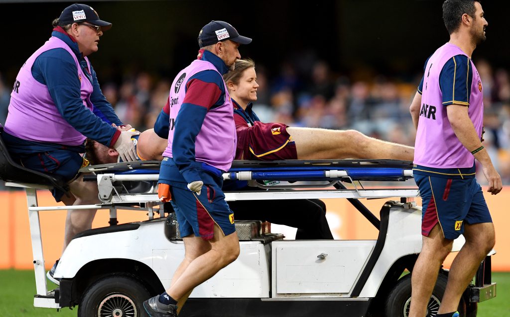 Harris Andrews is taken off the field after the collision with Cameron. Photo: AAP/Dan Peled