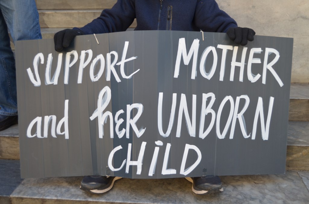 A pro-life protester who takes part in a prayer vigil outside the abortion clinic, here protests abortion law review at Parliament House. Photo: Angela Skujins