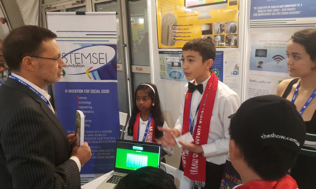 Max Weir explains his device to Australia's High Commissioner at Malaysia's World Young Inventors Exhibition.