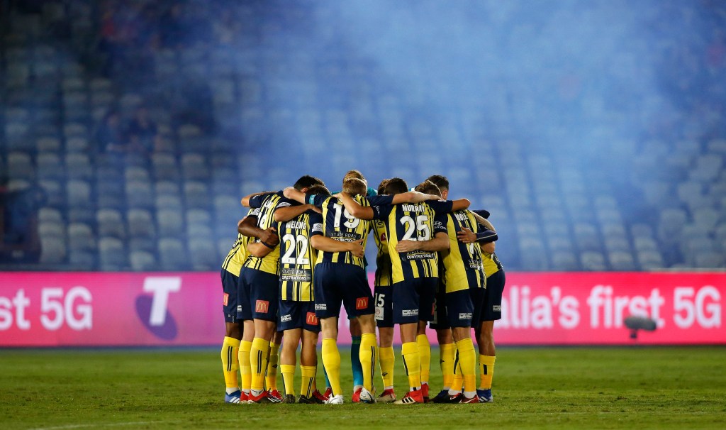 Mariners players huddle in front of a bare stand at their home stadium in Gosford in April. Photo: AAP/Darren Pateman