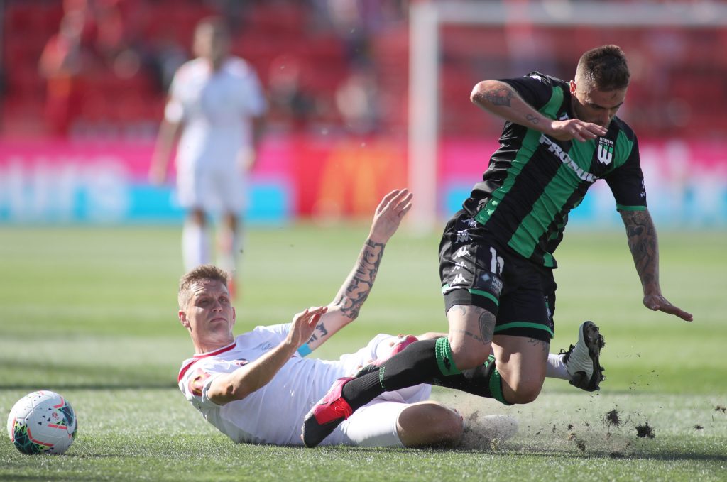 Michael Jakobsen clashes with Western United's Josh Risdon in Round 22. Photo: AAP/Kelly Barnes 