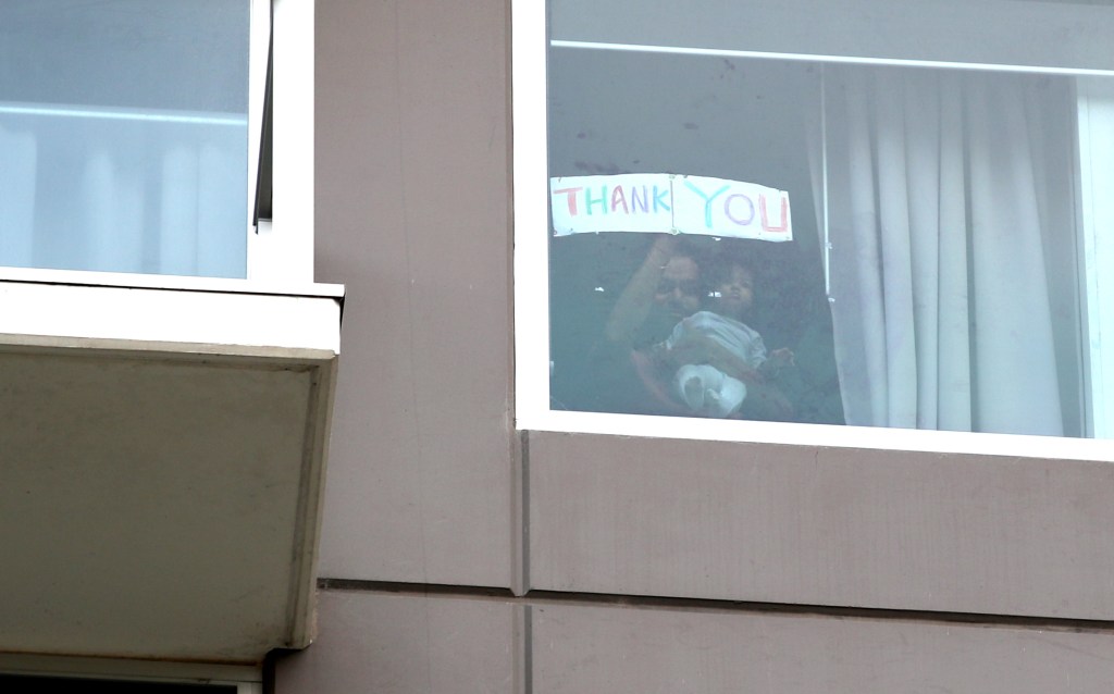 A Thank You sign is held up inside Adelaide's Pullman Hotel as hundreds of repatriated Australians prepare to end 14 days isolation. Photo: AAP/Kelly Barnes
