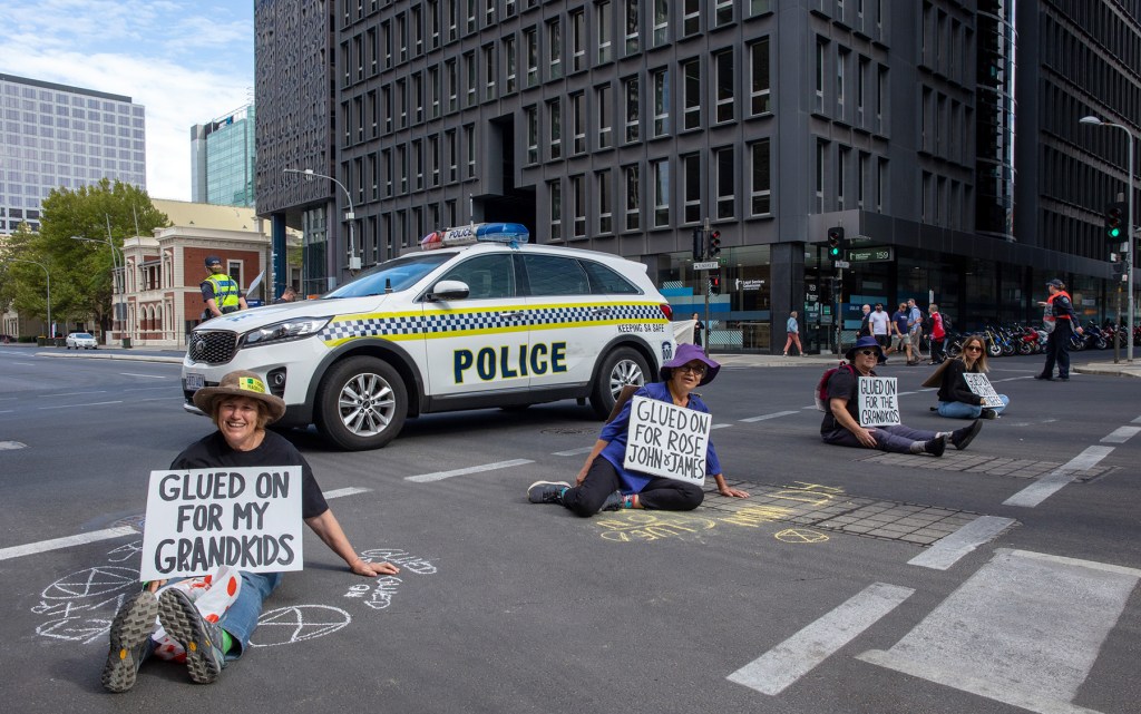 Extinction Rebellion protestors glued to Flinders Street this morning (Photo: Tony Lewis/InDaily)