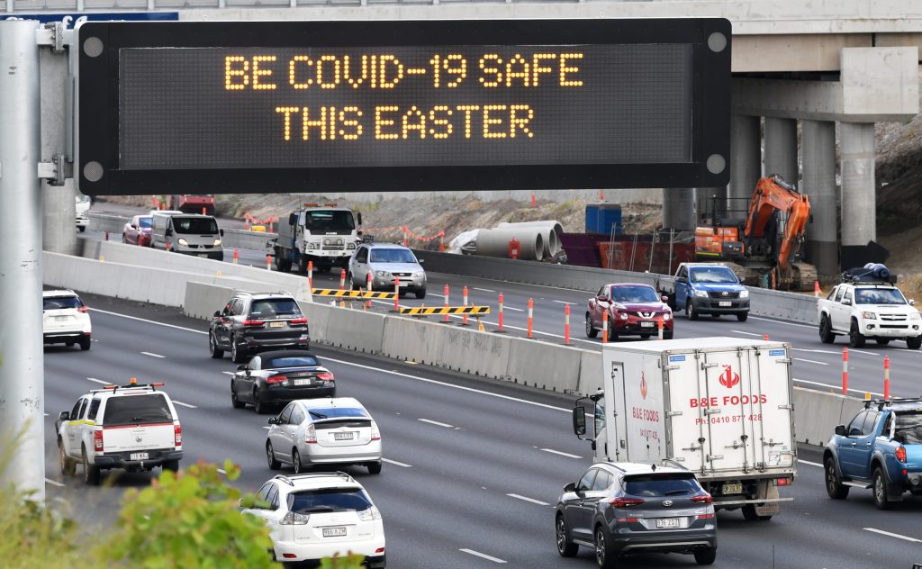 A traffic sign displaying a COVID-19 on the Pacific Motorway in Brisbane. Image: AAP Image/Darren England.