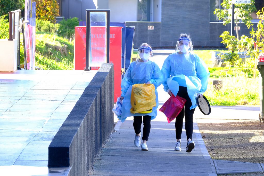 Health workers at Ariele Apartments in Maribyrnong, north-west of Melbourne, on Thursday, July 15, 2021.(AAP Image/Luis Ascui)
