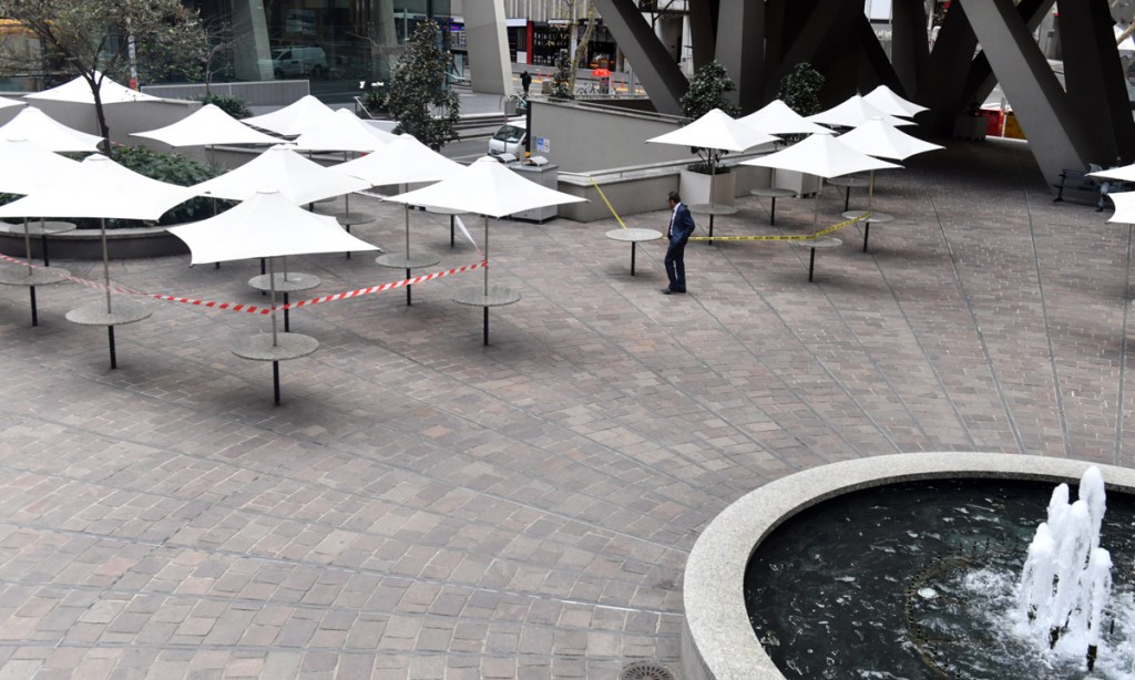 An office worker walks in a deserted food square in the central business district in Sydney (AAP Image/Mick Tsikas)