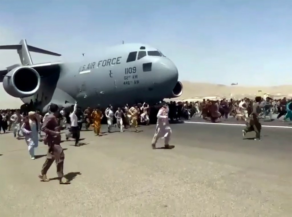 Afghans run alongside a U.S. Air Force plane as it tries to leave Kabul airport. Image supplied AAP, verified UGC via AP