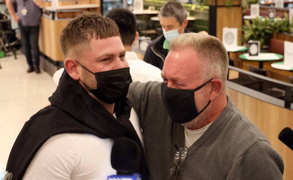 A father and son reunited at Adelaide Airport yesterday. Photo: Tony Lewis/InDaily
