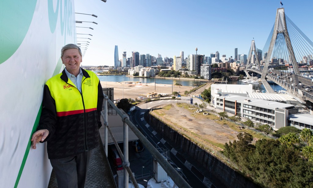 Coopers Brewery managing director Dr Tim Cooper with the billboard overlooking Sydney Harbour. Photo: Supplied.