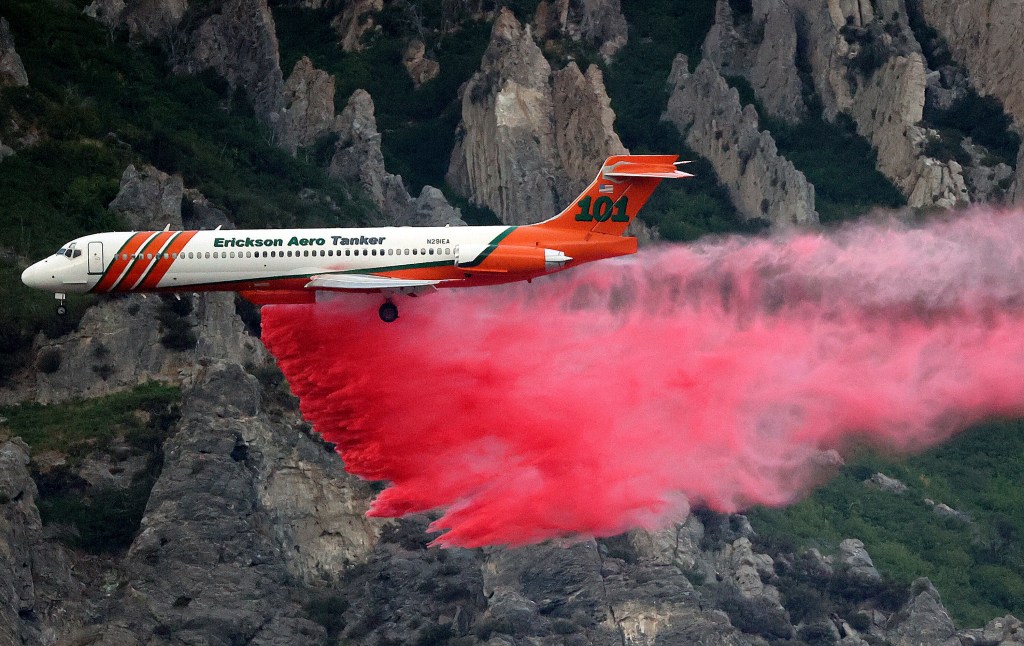 An Erickson Aero Tanker drops fire retardant over a wildfire in Springville on Monday. Photo: Kristin Murphy/The Deseret News via AP