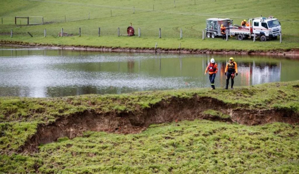 Emergency workers inspect a collapsing wall which threatened to release water from a private dam into Echunga. Photo: AAP/Matt Turner