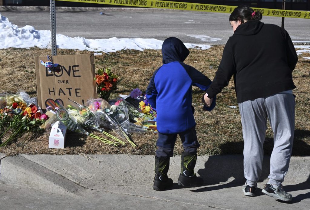 Kristen Morris and her son, Kai Morris, 6, walk away from a memorial Sunday morning for the victims of a shooting at Club Q in Colorado Springs. Photo: Christian Murdock/The Gazette via AP