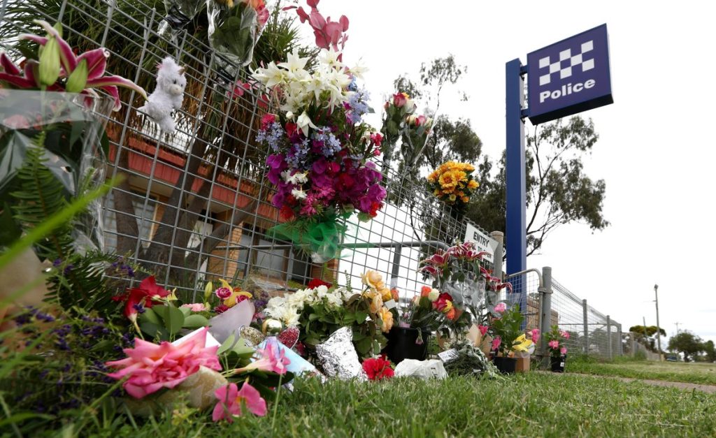 Tributes outside Tara Police station in Queensland after two of its officers were shot dead during a missing persons inquiry at a remote property. Photo: AAP/Jason O'Brien