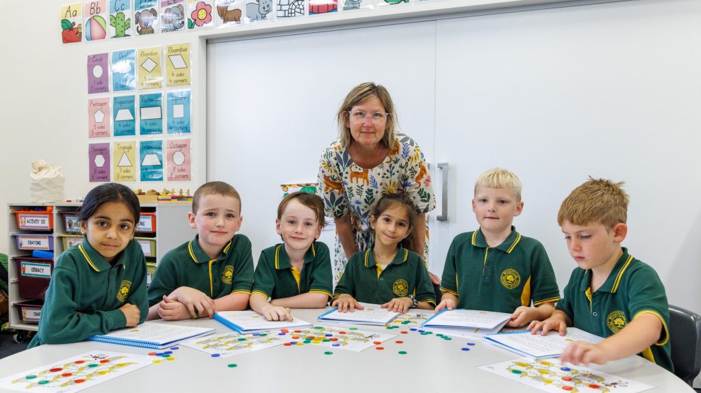 Woodville Primary teacher Olivia O’Halloran helps year one students with their reading. Photo: Tony Lewis/InDaily