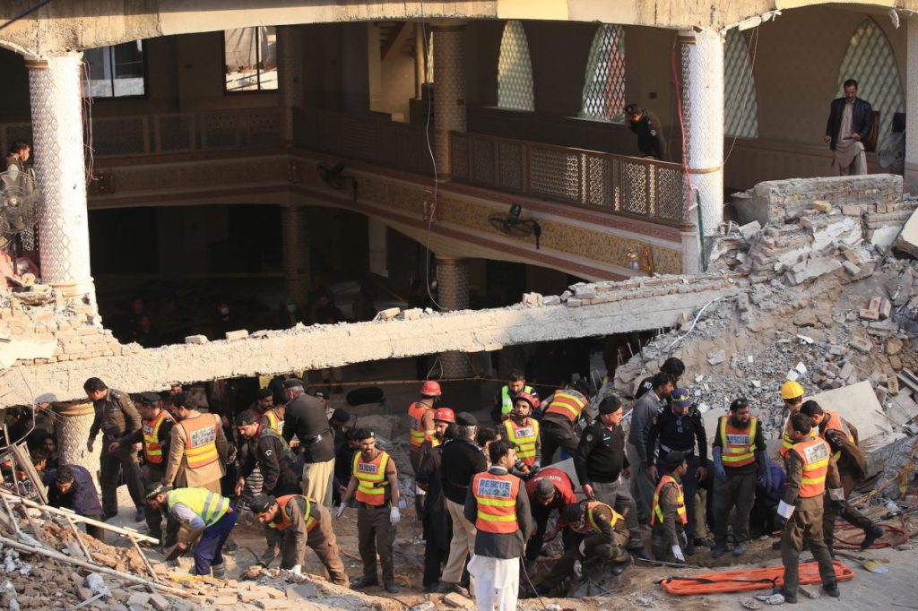 Rescue workers at the scene of a blast at a mosque in Peshawar, Pakistan where at least 59 people were killed. Photo: EPA/Bilawal Arbab