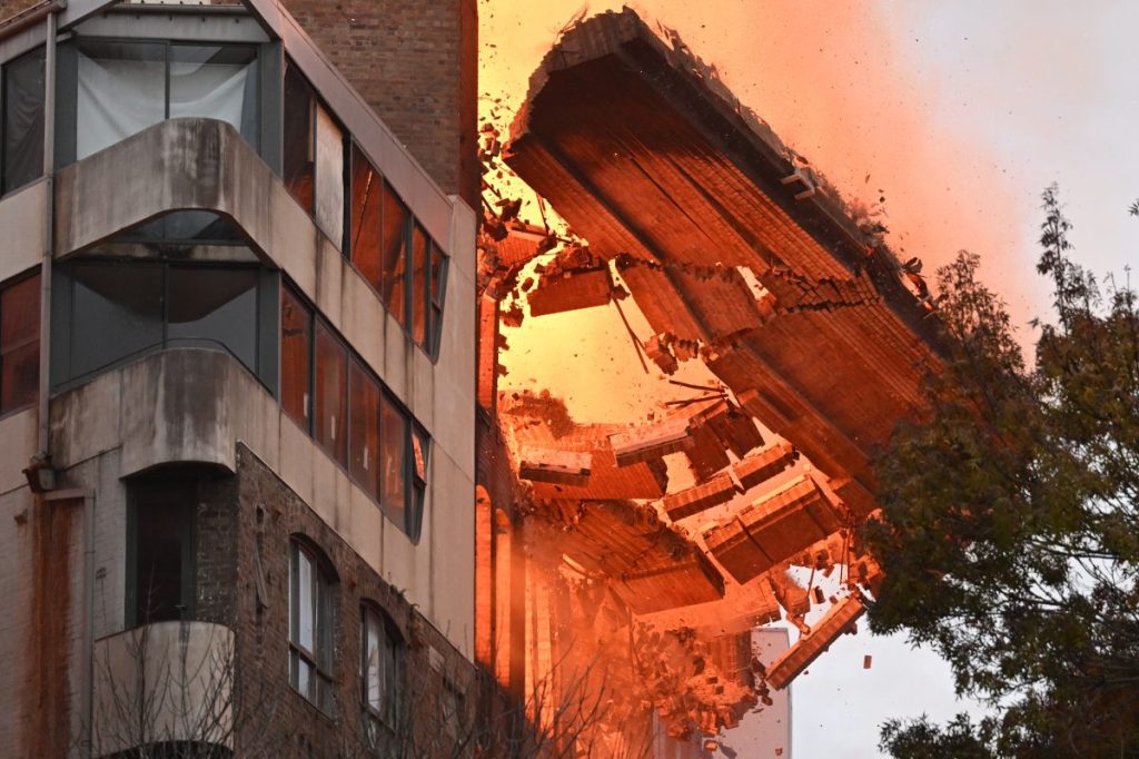 A wall collapses as a heritage building burns in Sydney's inner-city Surry Hills. Photo: AAP/Dean Lewins