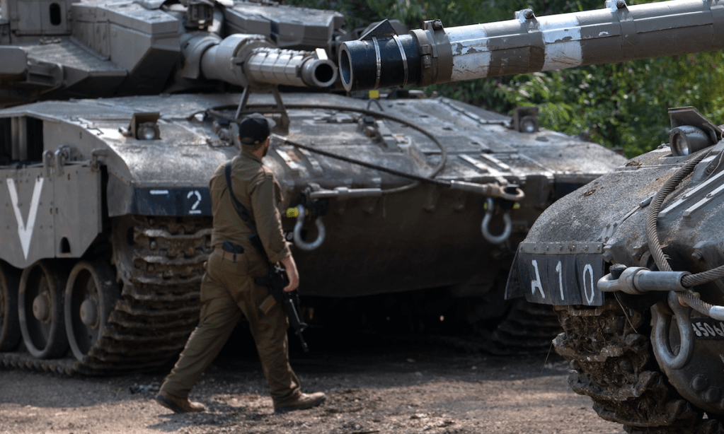 An Israeli soldier and tanks near the border with Lebanon. Photo: EPA/AYAL MARGOLIN 