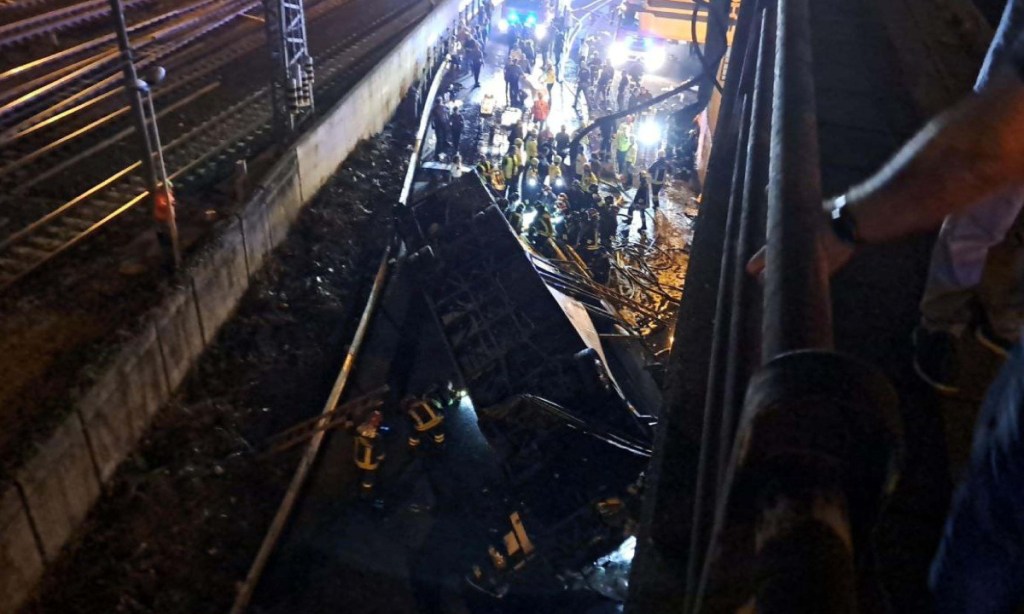 Rescue personnel works at the site where a bus fell from an elevated section in Mestre, near Venice, to crash down and land on the railway tracks that run alongside the road. Photo: 