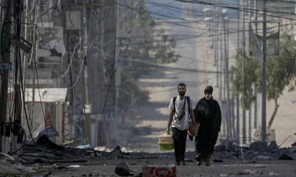 A Palestinian man and his mother leave following an Israeli air strike in the west of Jablaiya refugee camp, northern Gaza Strip, following an Israeli air strike, 11 October 2023. Photo: EPA/Mohammed Sabe 