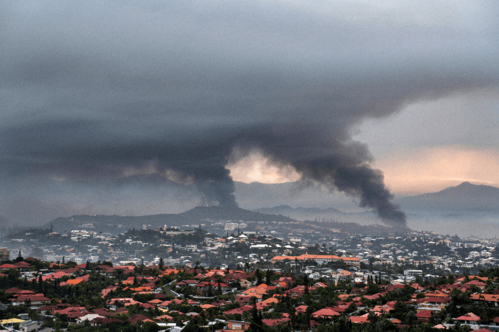 Smoke rises above Noumea from fires sparked during rioting. Photo: AP