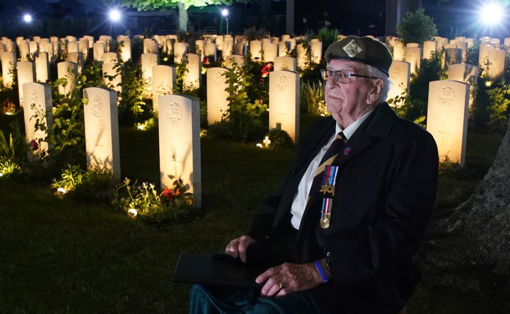 D-Day veteran Sergeant Richard Brock sits next to some of the 4600 lit headstones during the Commonwealth War Graves Commission's Great Vigil to mark the 80th anniversary of D-Day at the Bayeux War Cemetery in Normandy, France, this week. Photo: Gareth Fuller/PA Wire