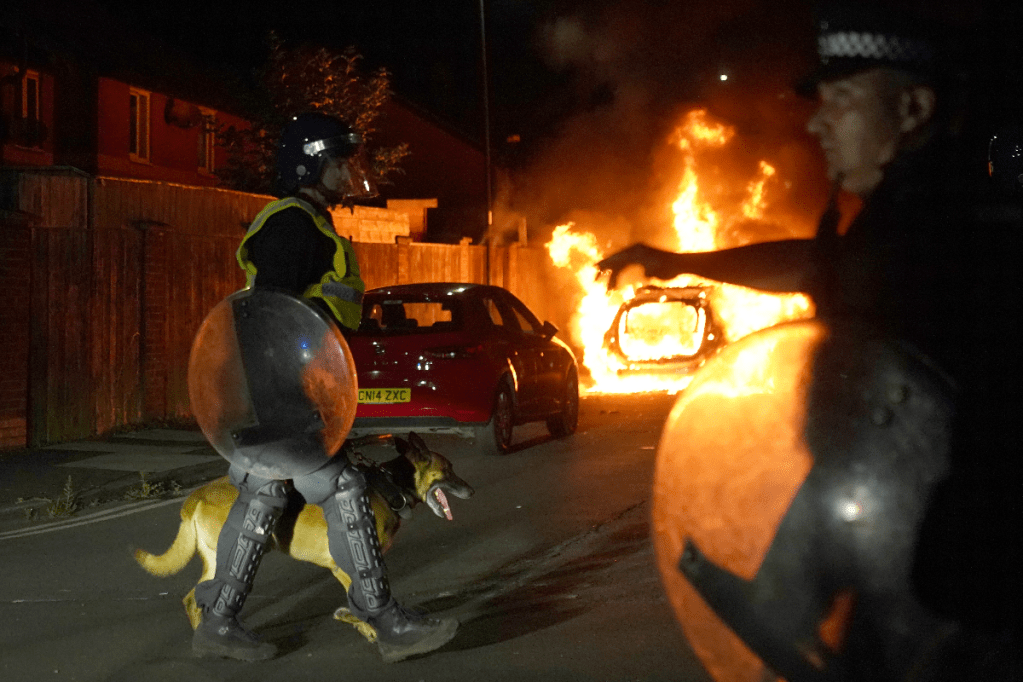 A police car burns during protests in the UK town of Hartlepool after three girls were stabbed to death in Southport. Photo: PA/Alamy