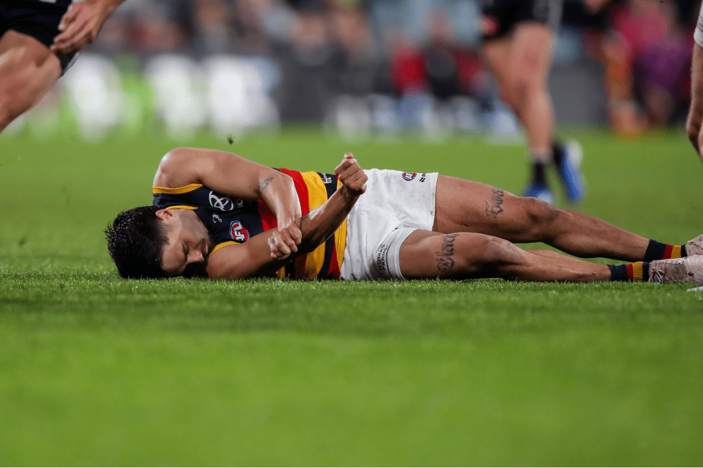 Adelaide's Izak Rankine was taken from the ground after being concussed following a bump by Port's Dan Houston. Photo: AAP